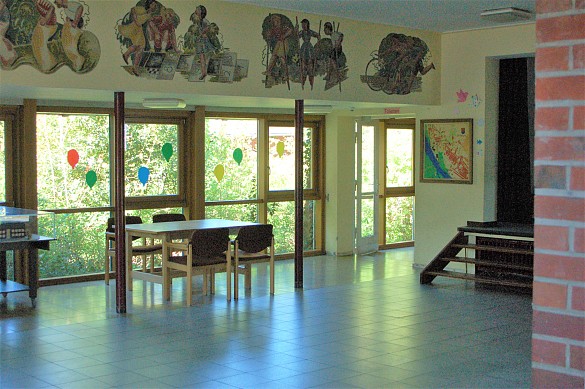 Die Aula mit Bühne, Tischen und Stühlen