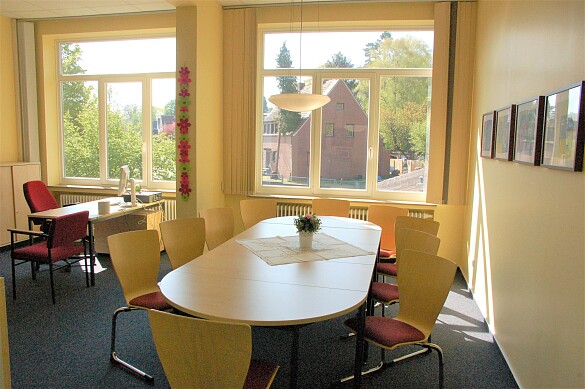 Raum mit großem Tisch und vielen Stühlen